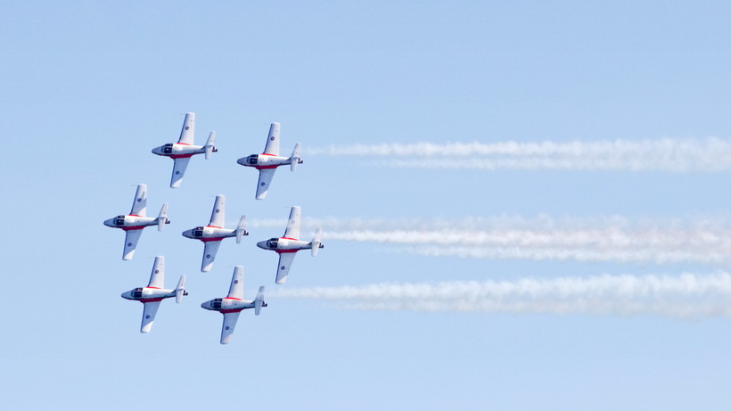 The snowbirds do a fly by showing the tops of their air planes.